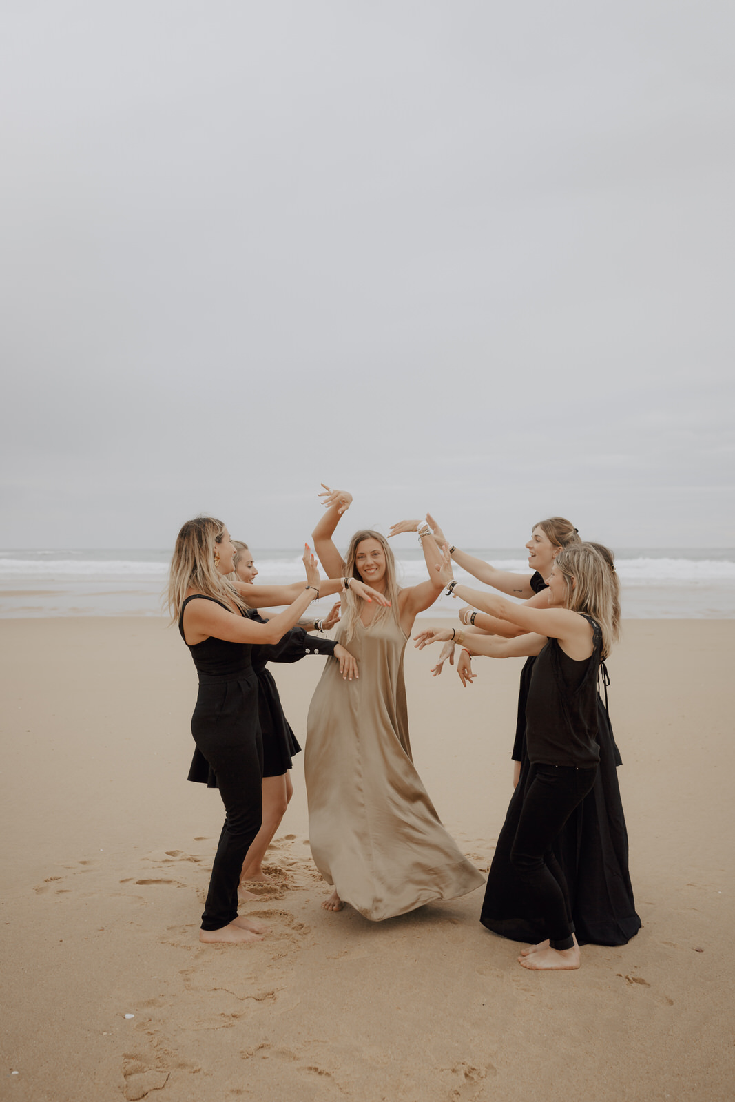 Séance photo lors d'un EVJF où des amis dansent sur la plage
